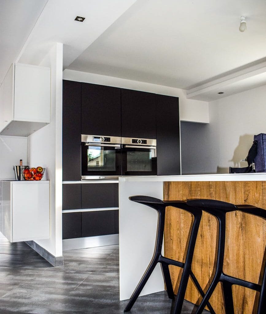 A contemporary kitchen featuring sleek cabinetry and elegant bar stools in a minimalist design.